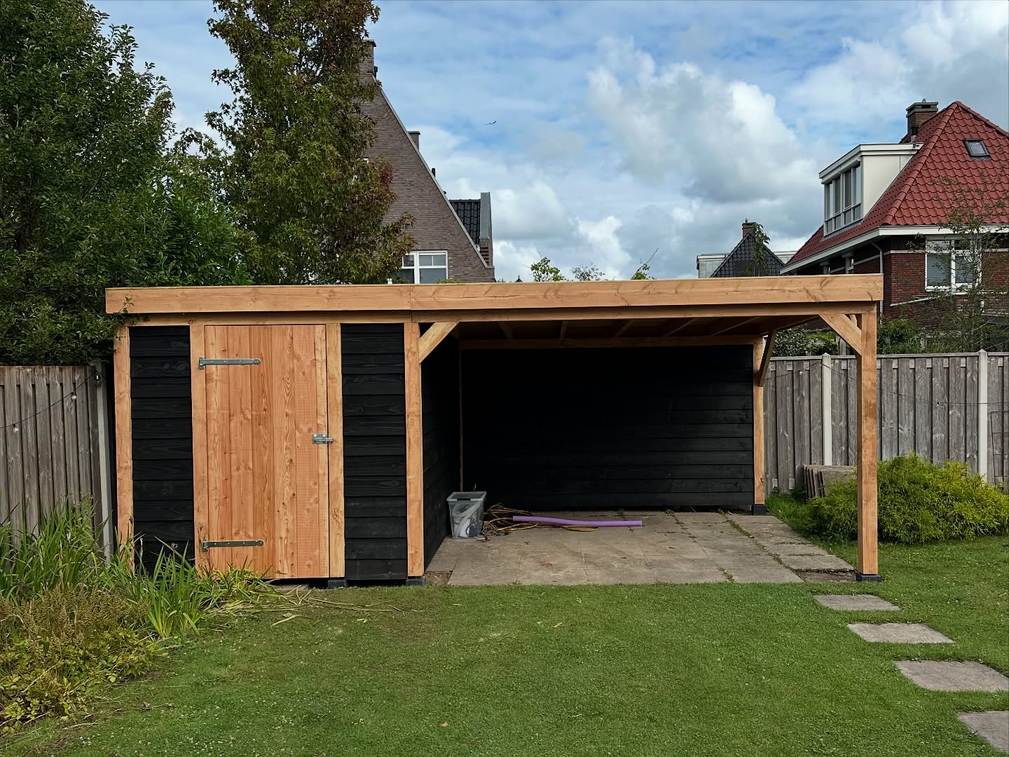 Stijlvolle houten overkapping in moderne tuin